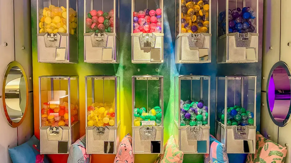 Distributeurs de bonbons remplis de billes colorées dans une confiserie
