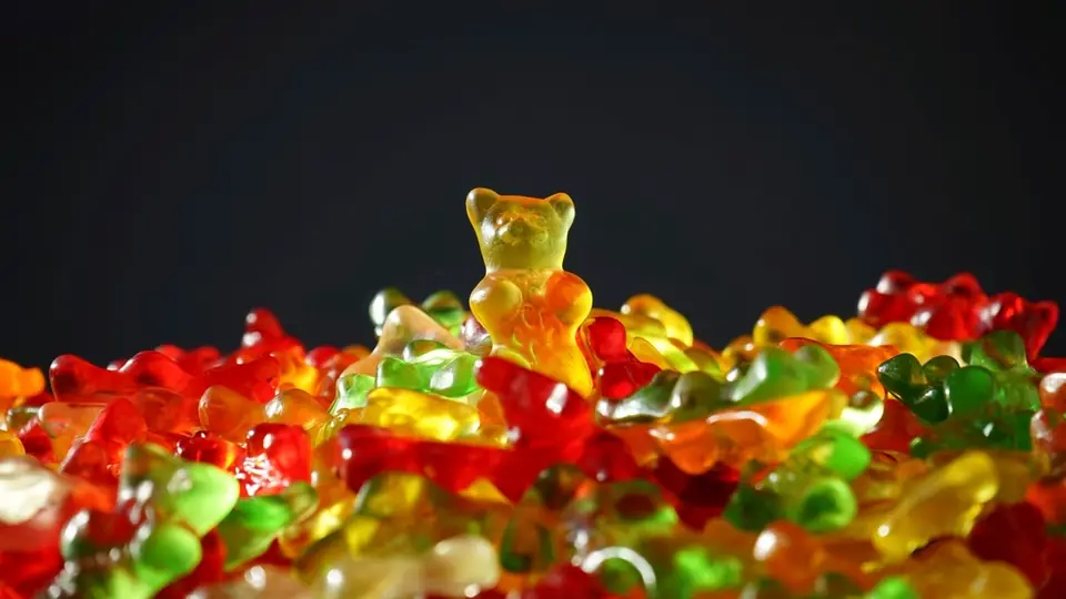 Oursons en gomme posés en tas devant un fond sombre